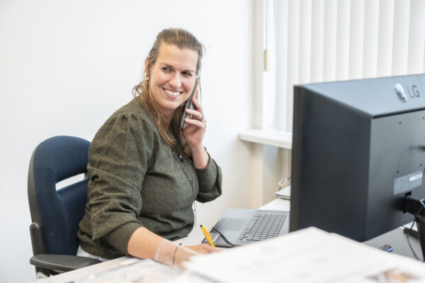 Mirella van Wijgerden aan de telefoon op het kantoor van deBesteEHBOdoos.